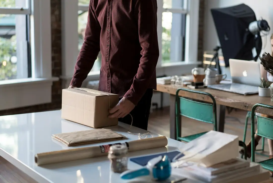 Business owner packing a customer order at a workbench